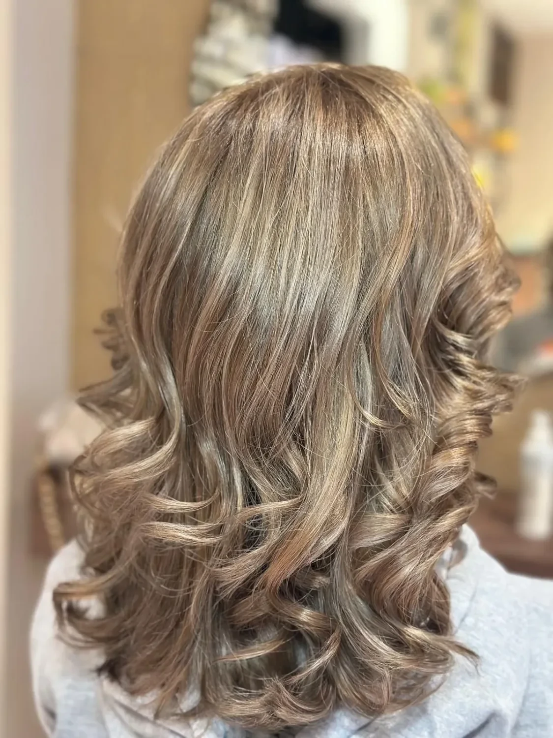 Mittellanges Haar in Bronde mit feinen hellen Partien und geföhnten Wellen